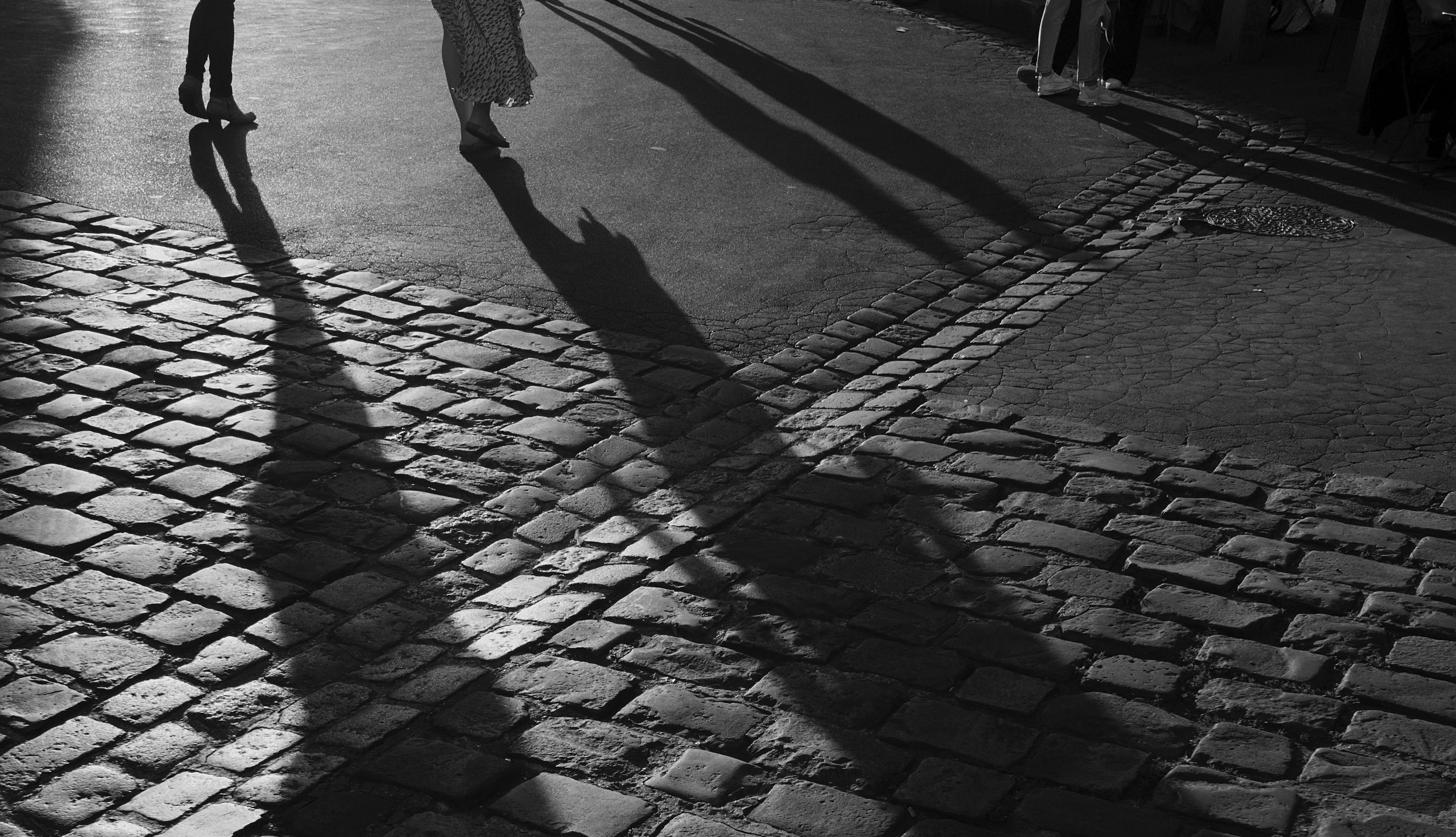 shadows of people on cobblestones